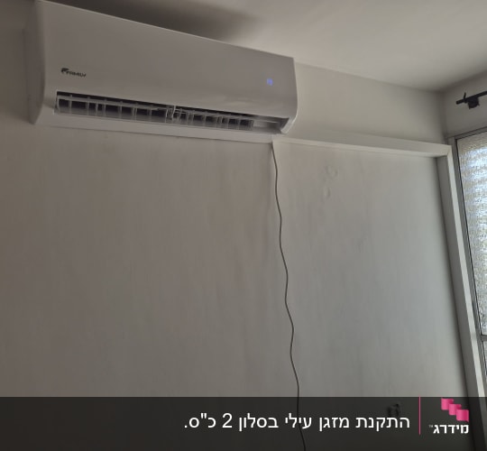 מזגן מותקן על קיר ליד חלון